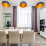 Nowoczesna jadalnia z białym stołem, krzesłami i designerską lampą