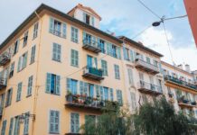 Balkon francuski w bloku – jak wykorzystać minimum miejsca, by stworzyć maksimum klimatu Kolorowa europejska kamienica z okiennicami i balkonami pod niebem