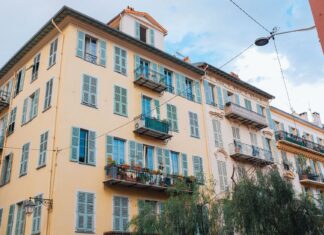 Balkon francuski w bloku – jak wykorzystać minimum miejsca, by stworzyć maksimum klimatu Kolorowa europejska kamienica z okiennicami i balkonami pod niebem